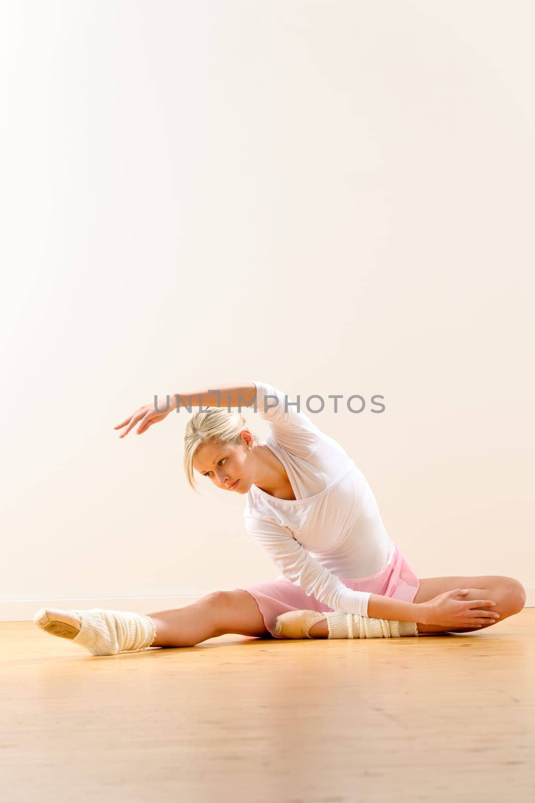 Ballet dancer in leaning posture exercise studio reaching woman ballerina