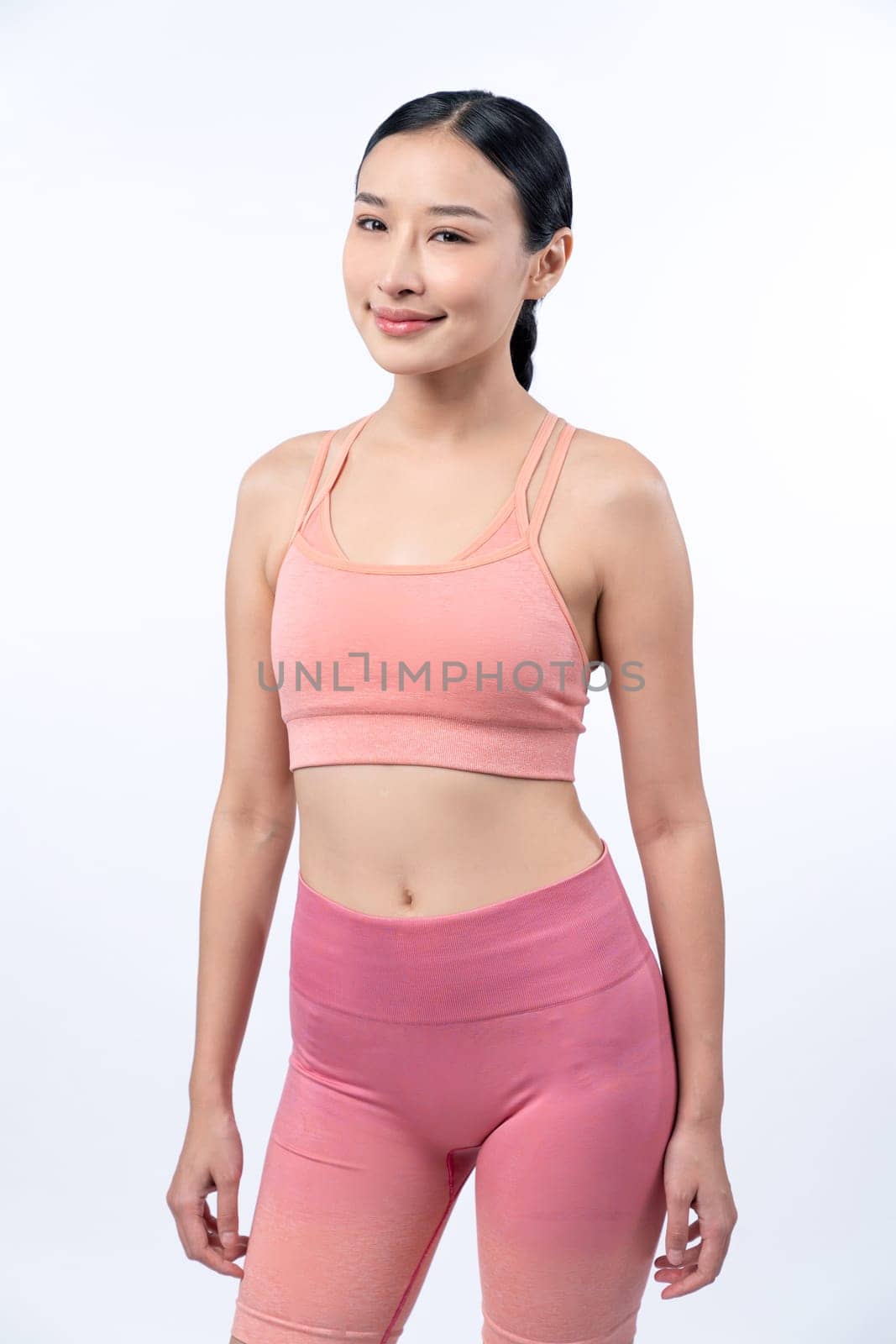 Young sporty Asian woman in sportswear holding salad bowl fill with vibrant of fruit and vegetable. Natural youthful and fit body lifestyle with balance nutrition on isolated background. Vigorous