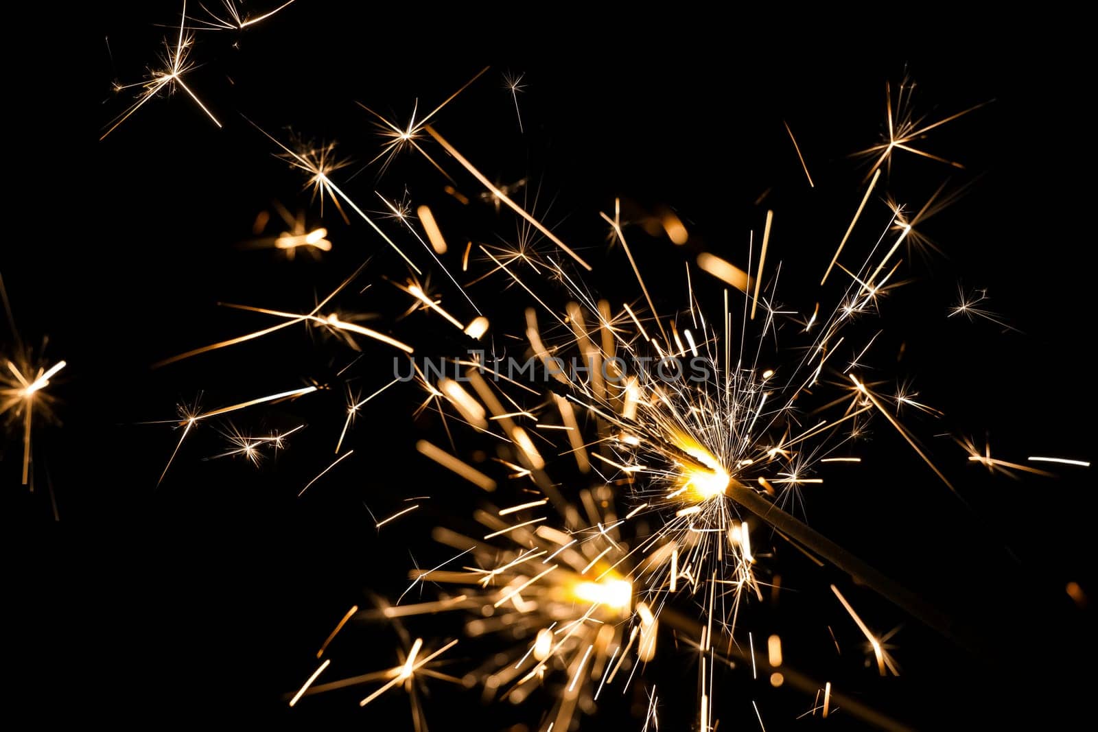 Close up ggroup of several bright firework sparklers over black, background for Christmas, wedding and Independence Day, low angle side view