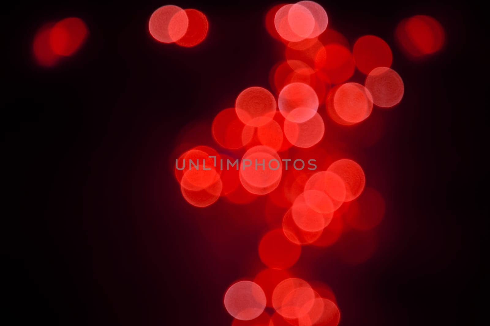 Abstract background of colorful bright scarlet red defocused bokeh of Christmas lights decoration over black in the night