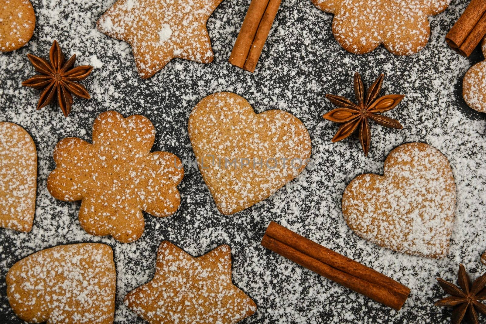 Gingerbread cookies and spices on black slate by BreakingTheWalls