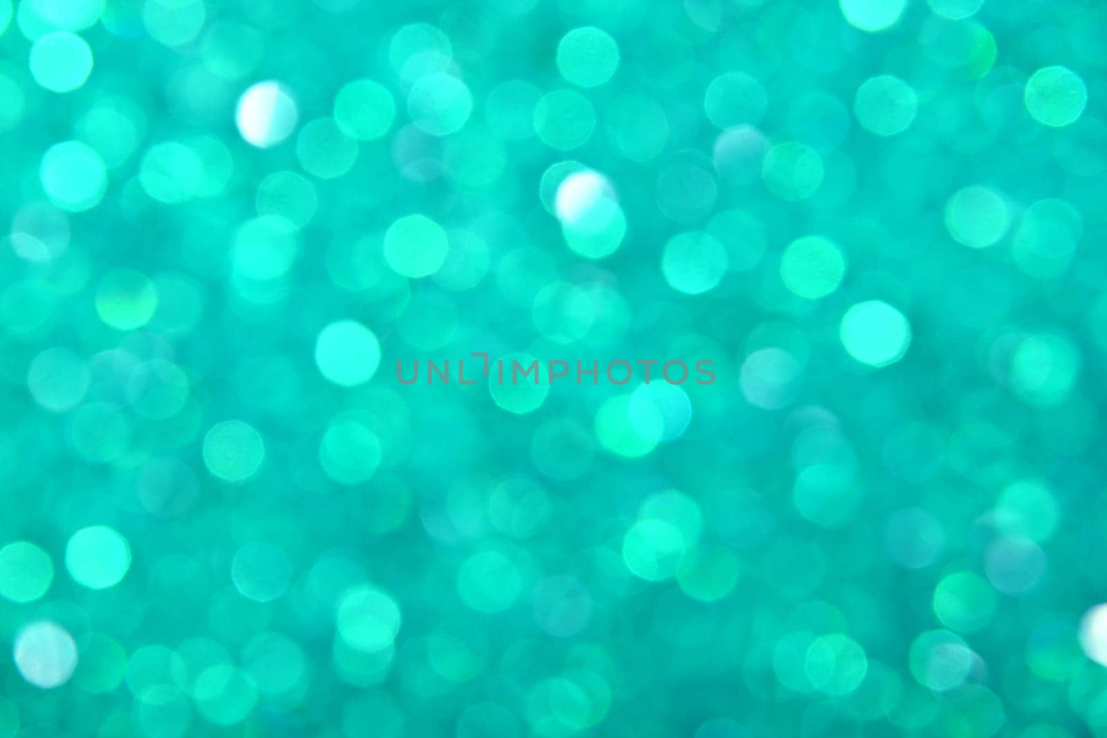 Abstract background of teal blue bokeh defocused blurred lights and glitter sparkles