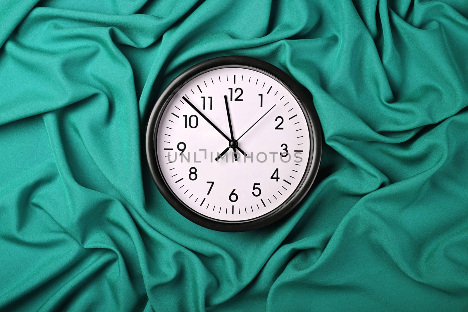 White clock over teal textile folded pleats by BreakingTheWalls