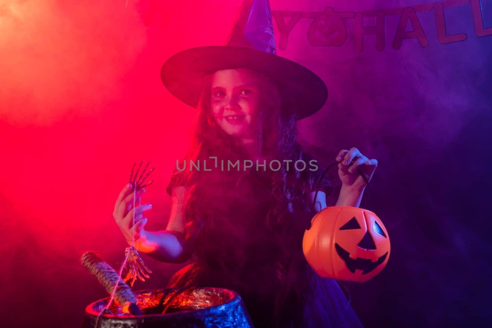 Child girl witch preparing a potion in the cauldron at halloween holidays. by Satura86