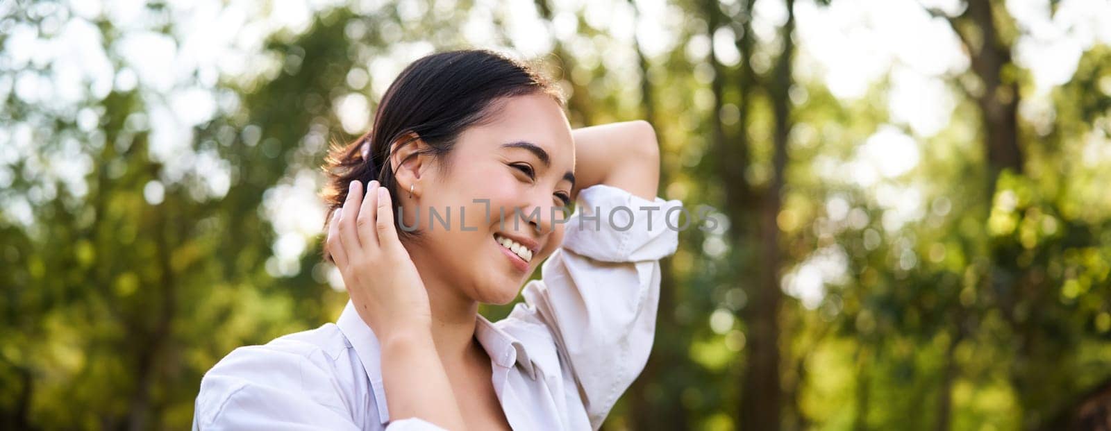 Women and beauty. Portrait of young happy asian woman walking on streets, enjoying stroll in park, smiling and looking around by Benzoix