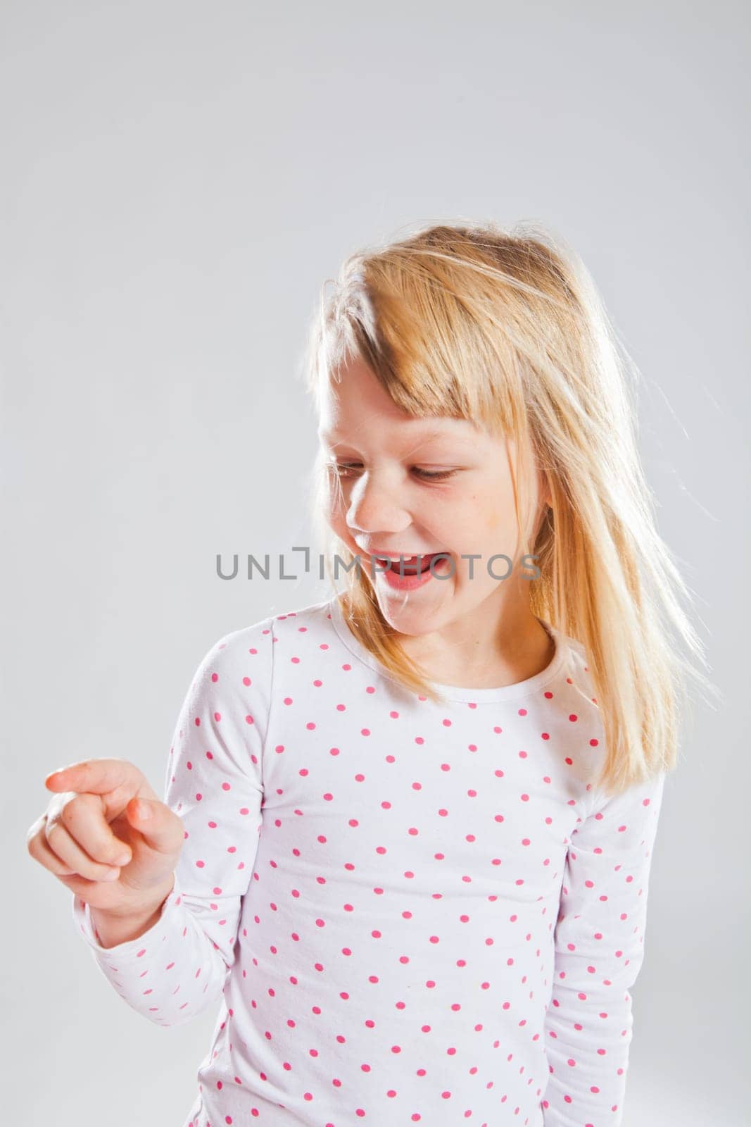 Studio portrait of happy smiling young pointing with finger