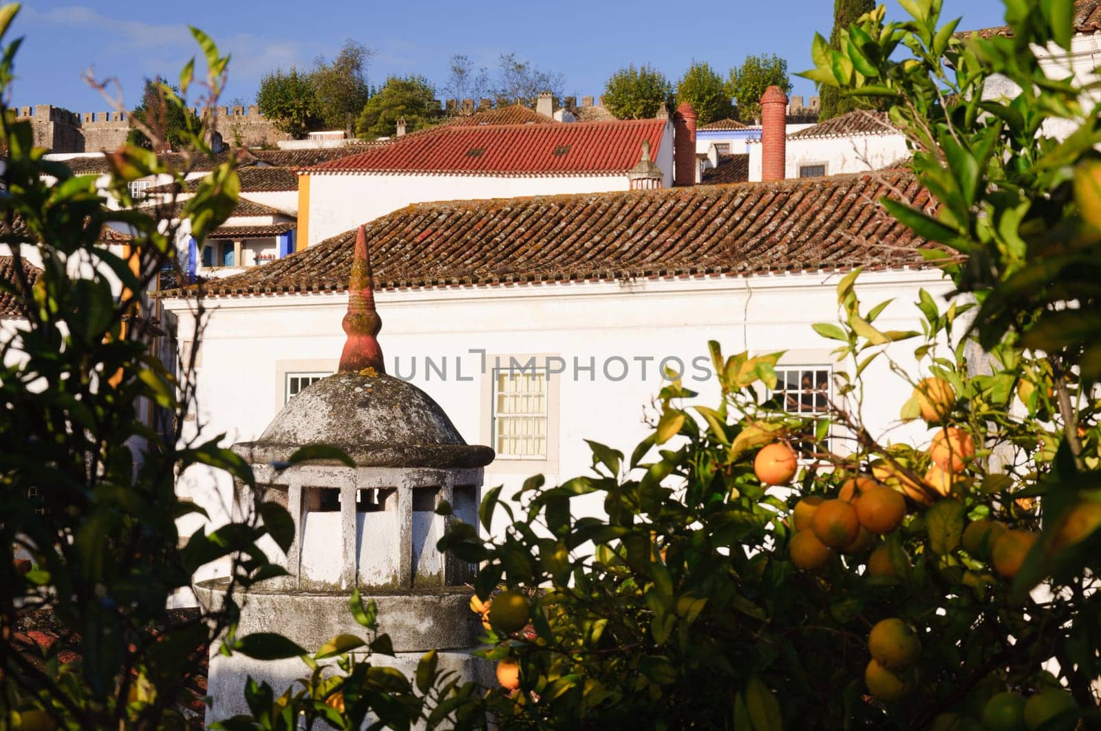 Medieval street in the  town of Obidos, Portugal with castle walls  in the background