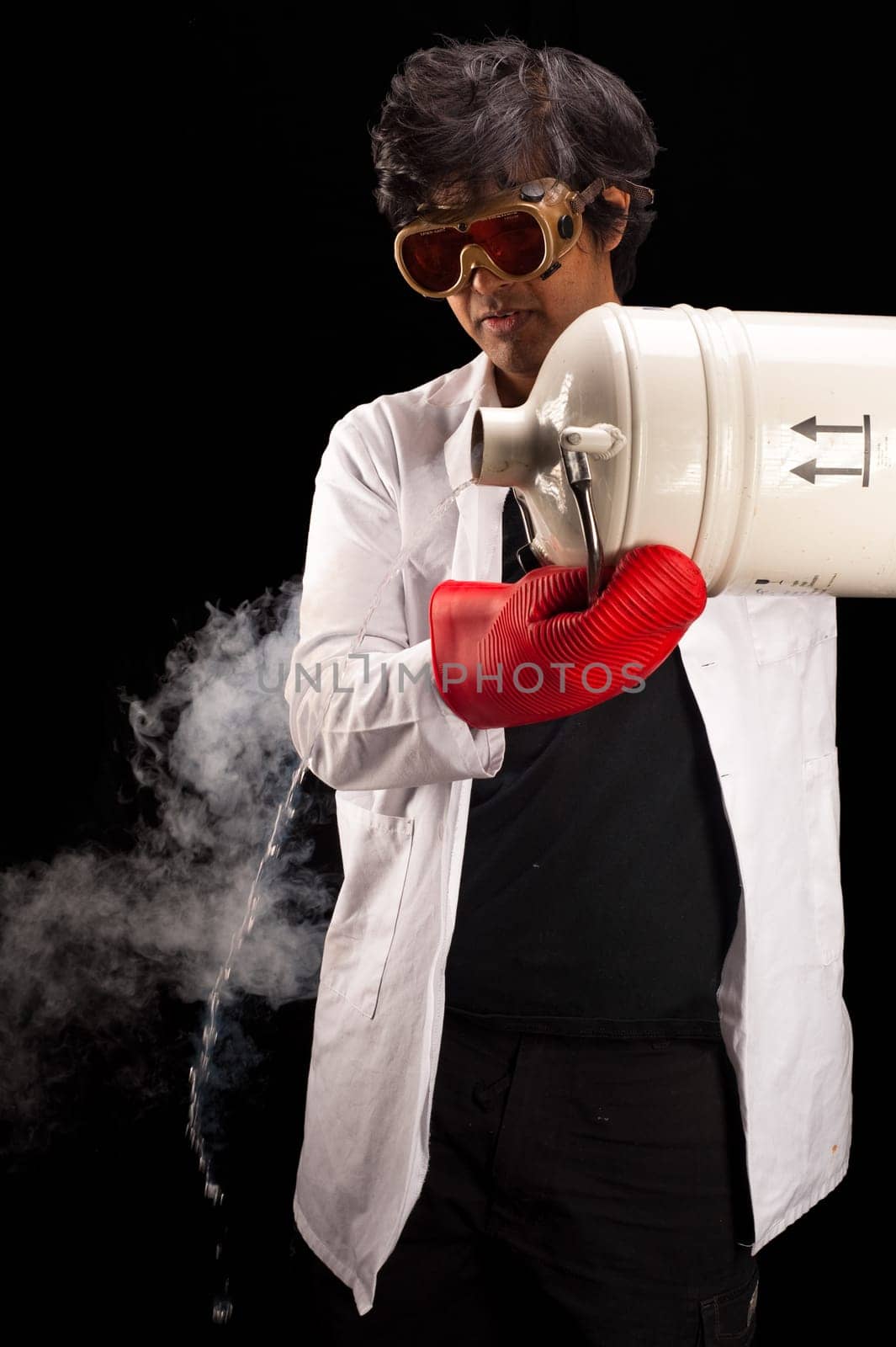 Indian scientist pouring from a dewar of liquid nitrogen