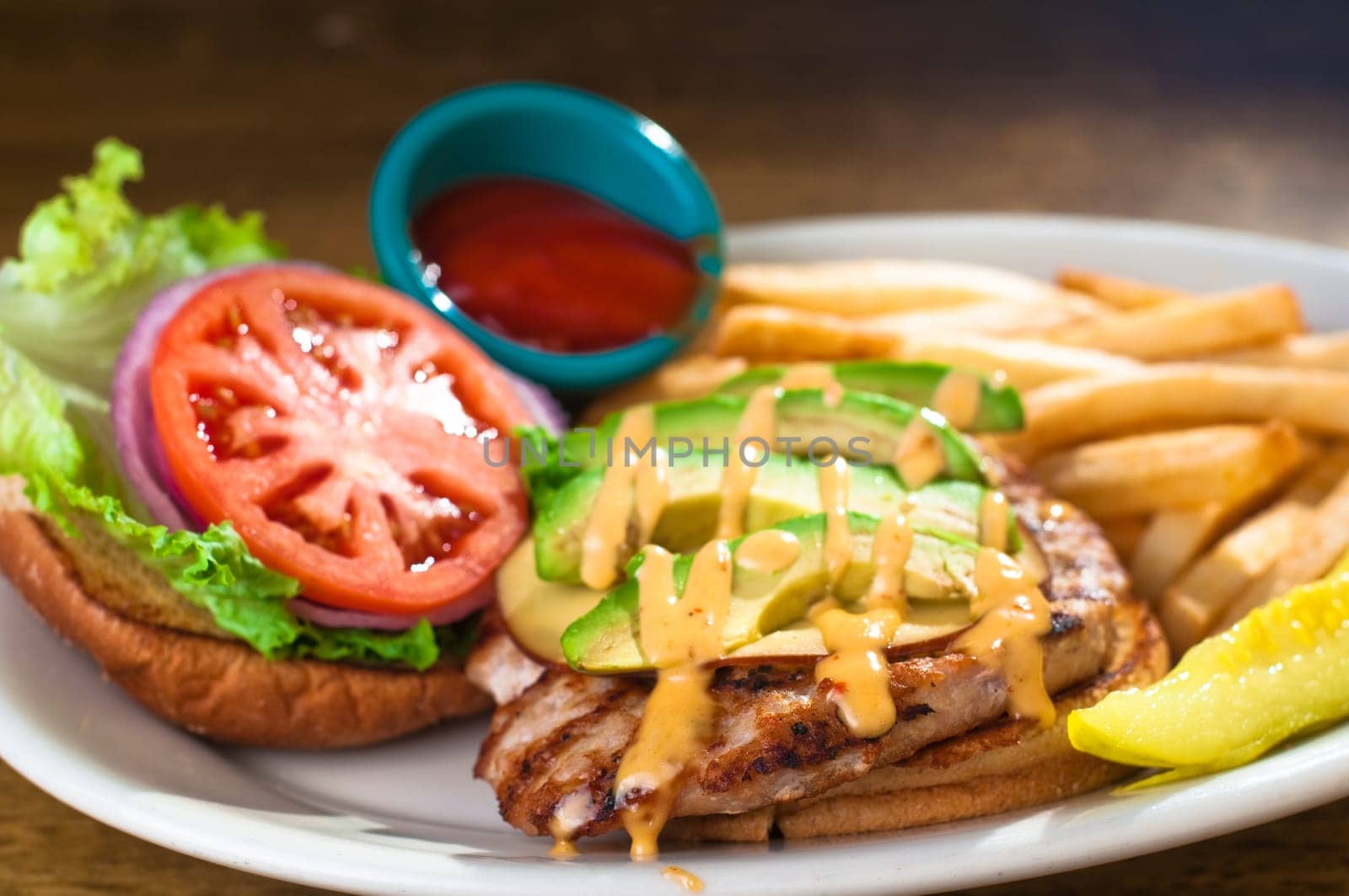 Avocado chicken burger with fries