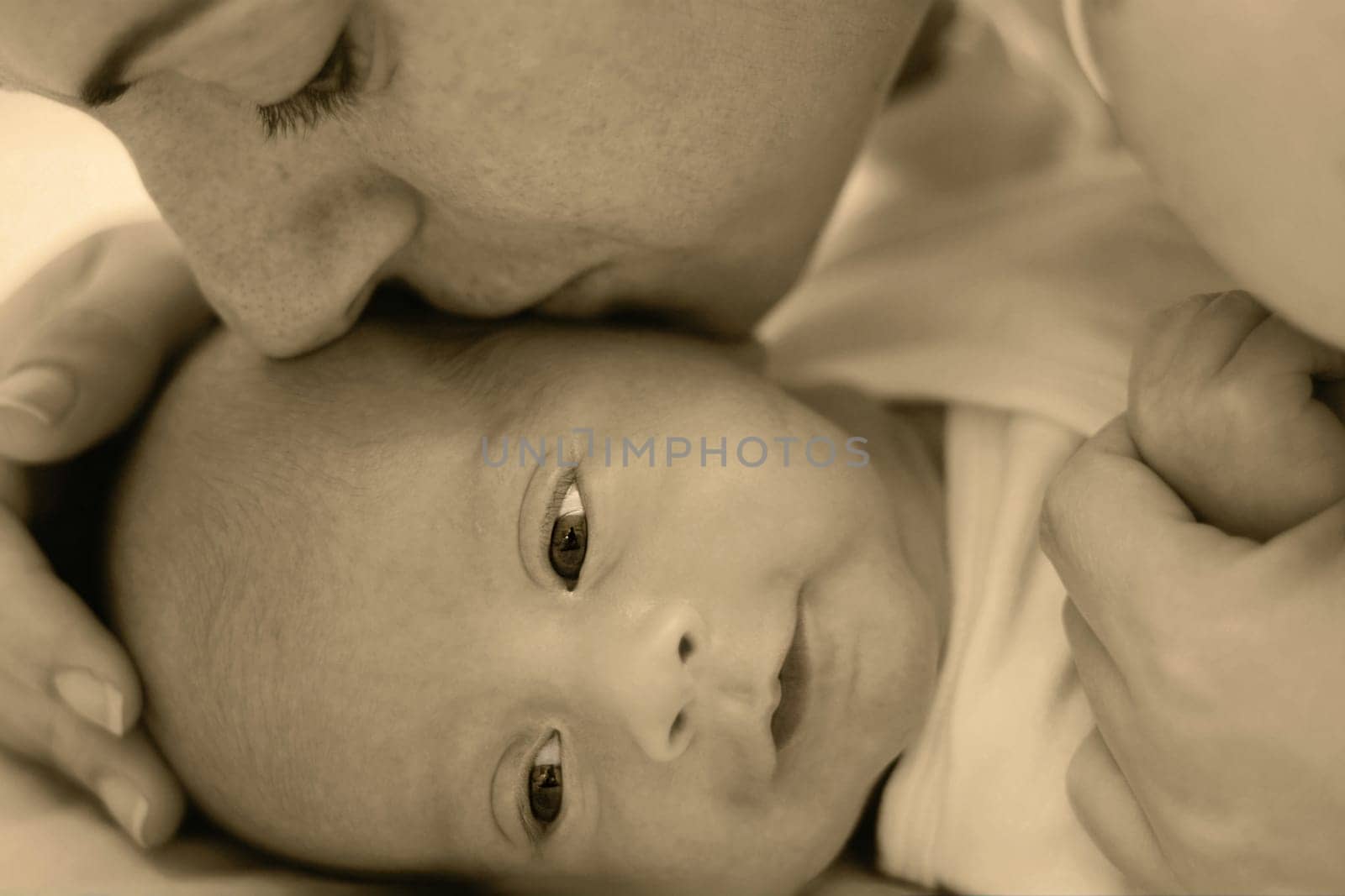 Happy young mother kissing a baby