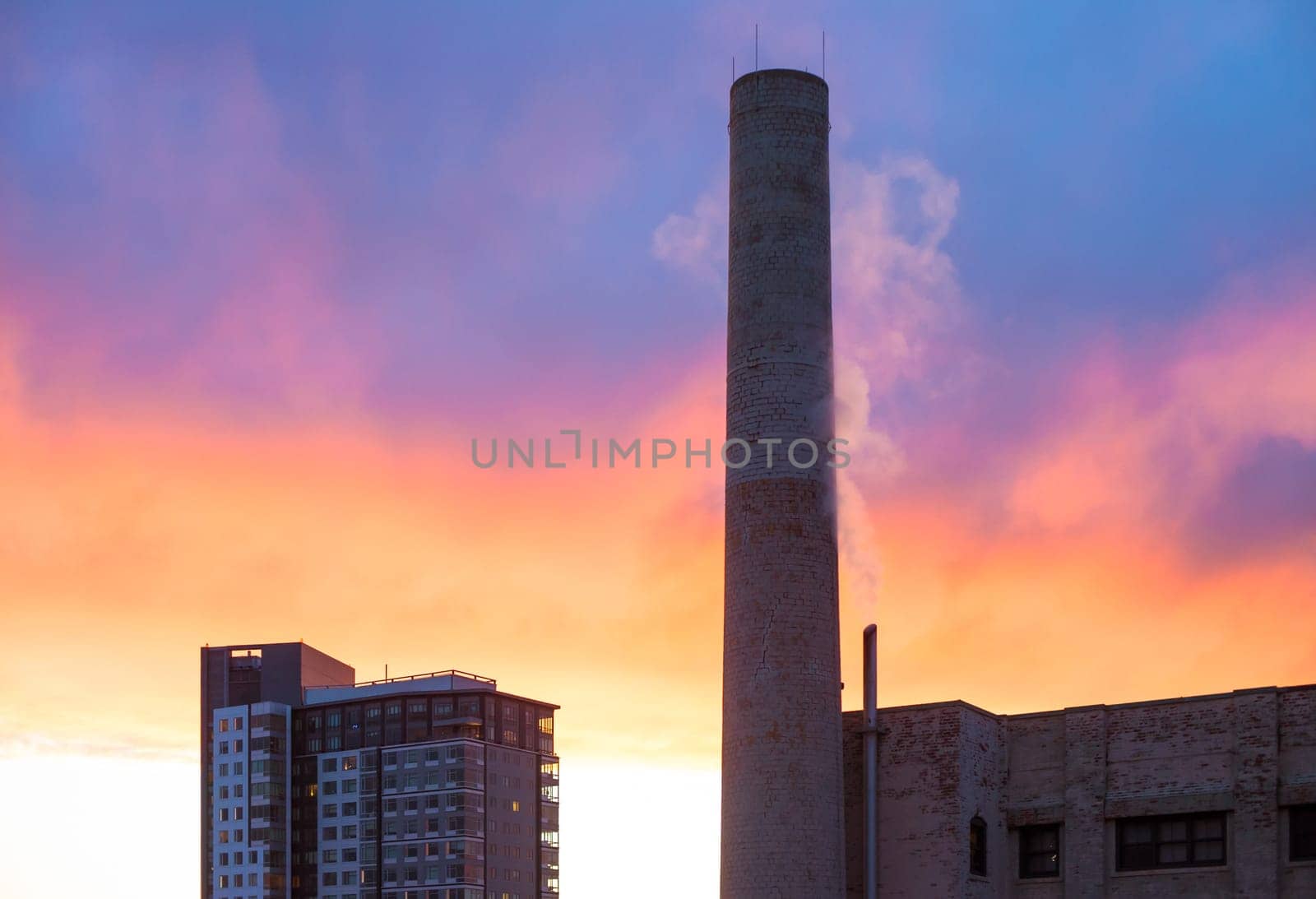Industrial smokestack with red and blue sunset