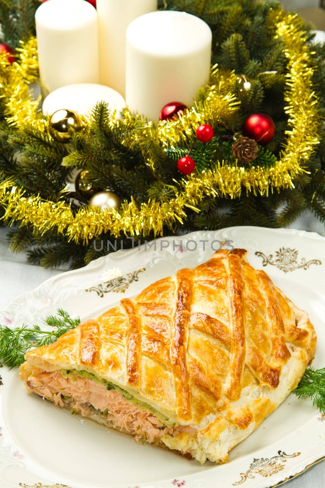 Traditional salmon in puff pastry with spinach and zucchini in christmas table