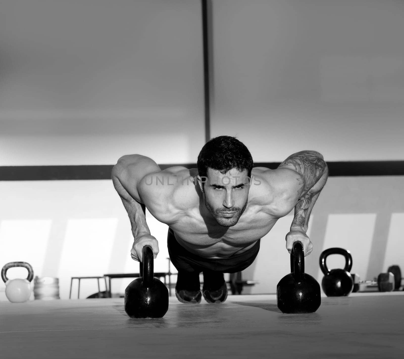 Gym man push-up strength pushup exercise with Kettlebell in a crossfit workout