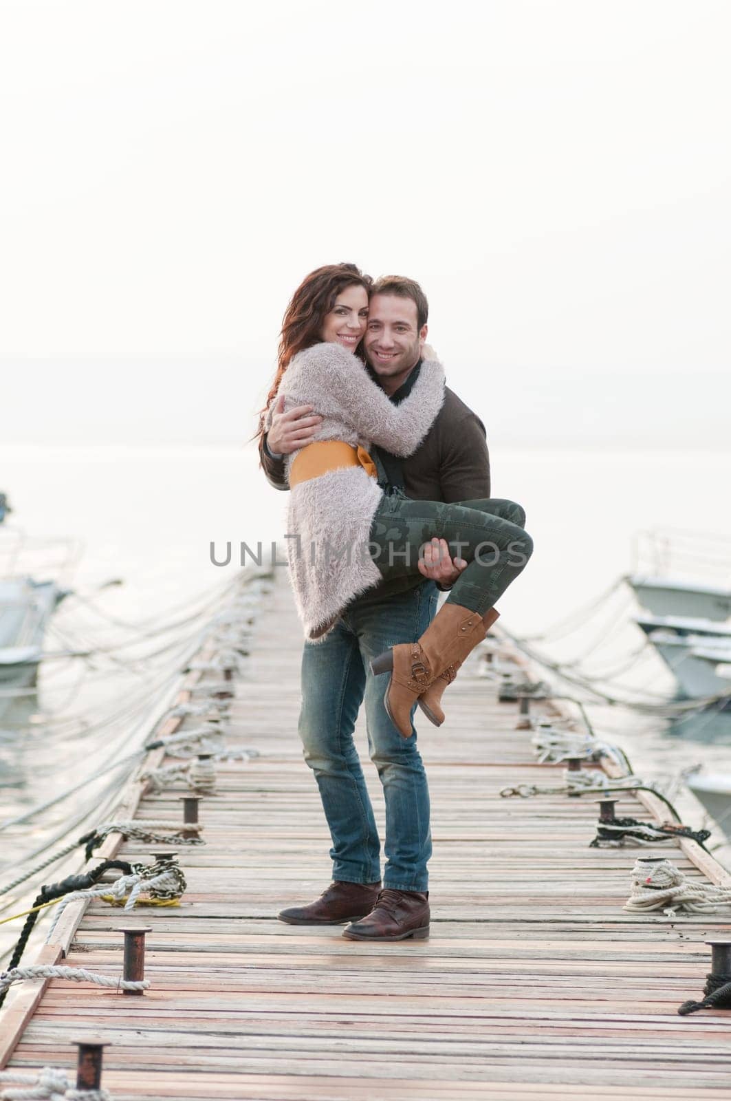 Beautiful relaxed couple on wooden pier in marina