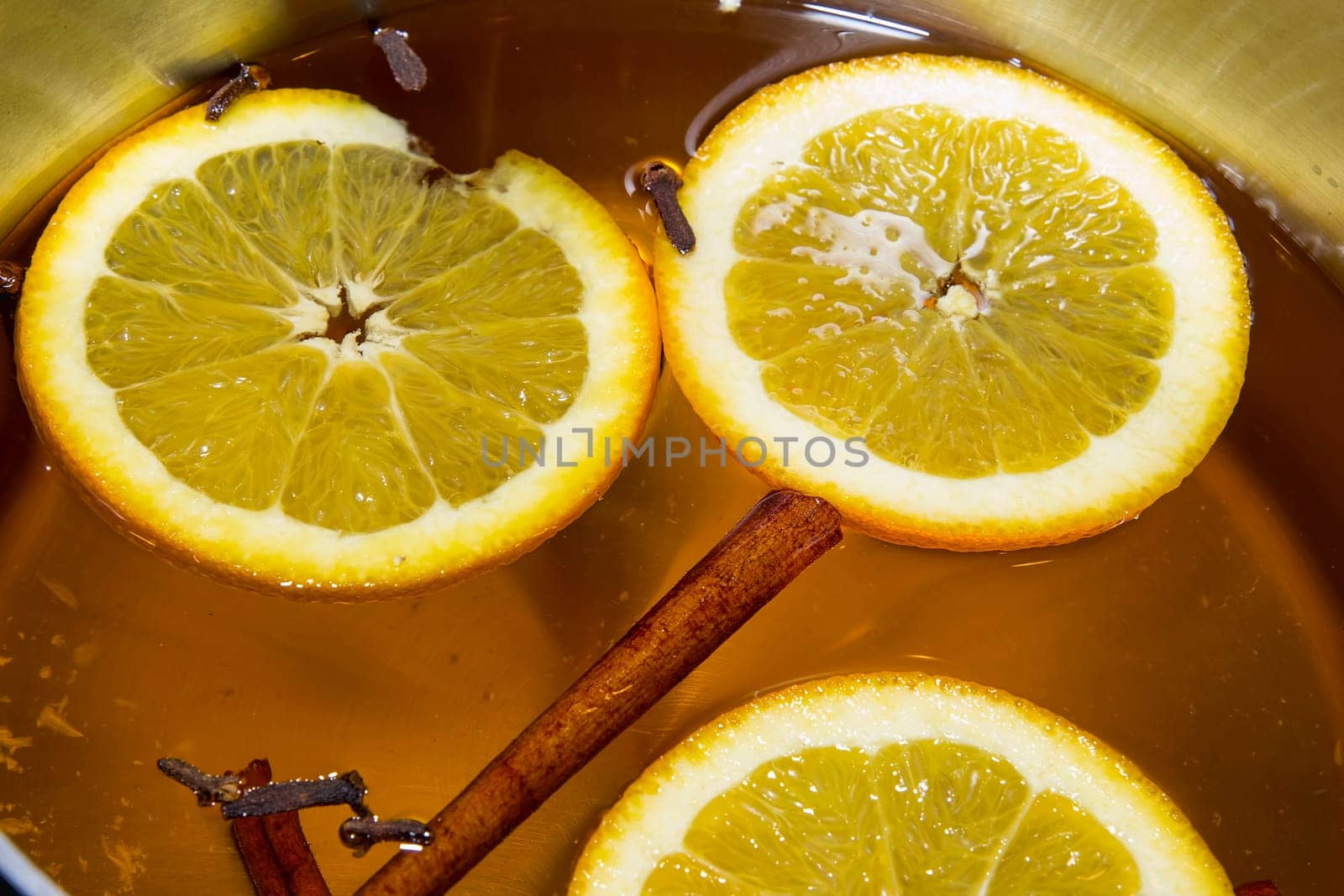 Boiling Apple Cider with Orange Slices Cloves and Cinnamon Sticks Closeup