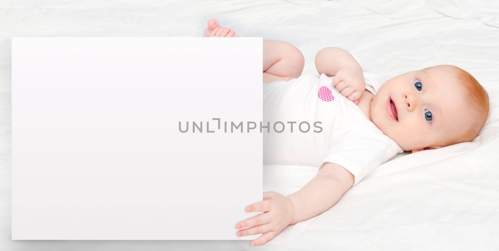 Cute Baby Girl Lying on Back Holding Sign