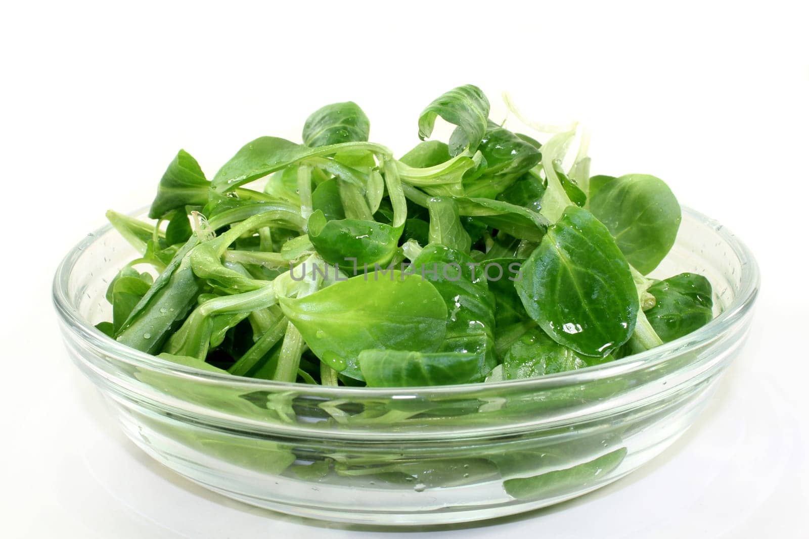 fresh lamb's lettuce in a glass bowl