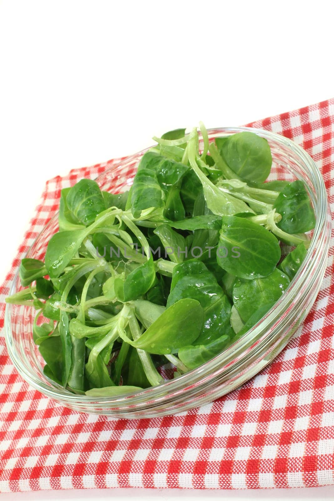 fresh lamb's lettuce in a glass bowl