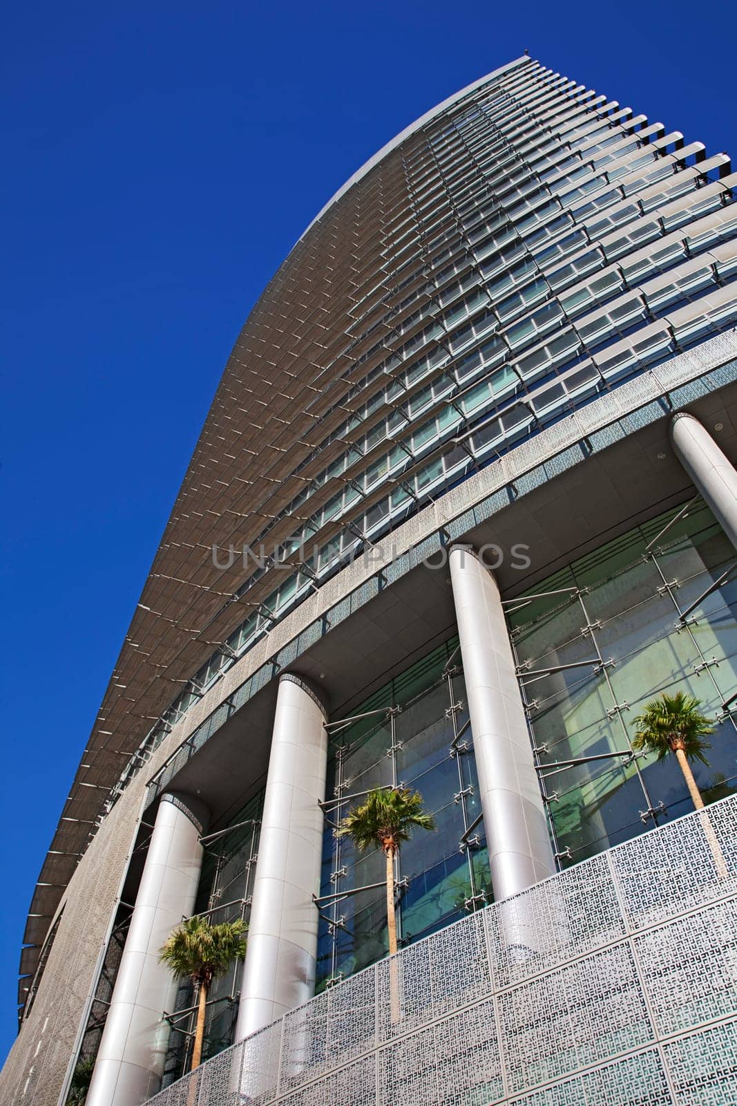 Perspective and underside angle view of modern glass building skyscrapers over blue sky