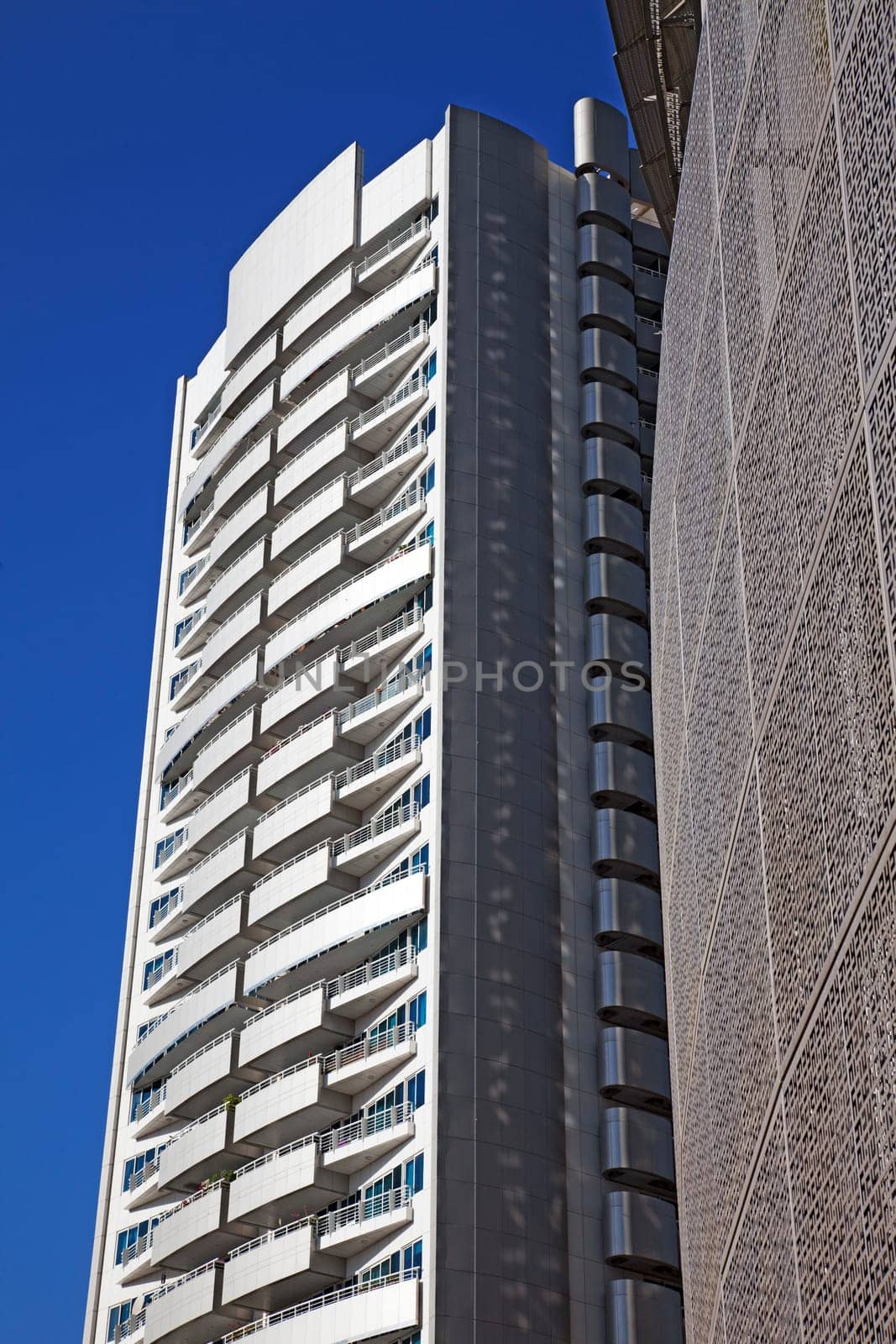 Perspective and underside angle view of modern glass building skyscrapers over blue sky