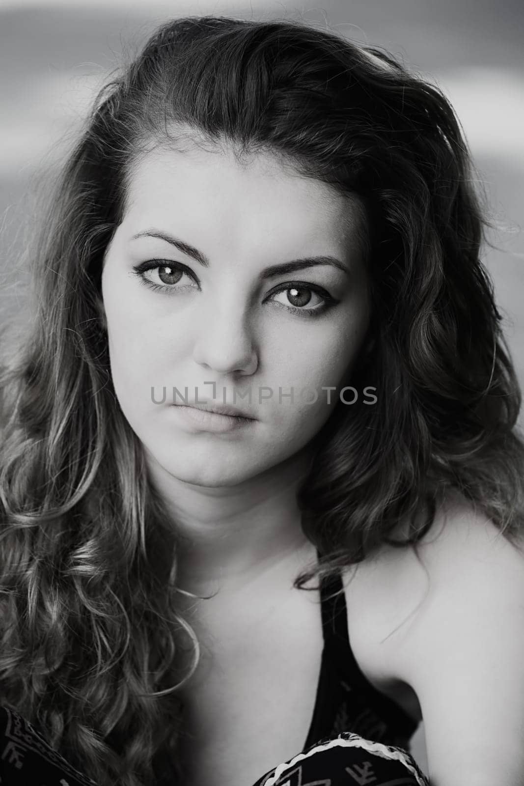 Portrait of a sad 20 year old woman looking at camera, black and white image.