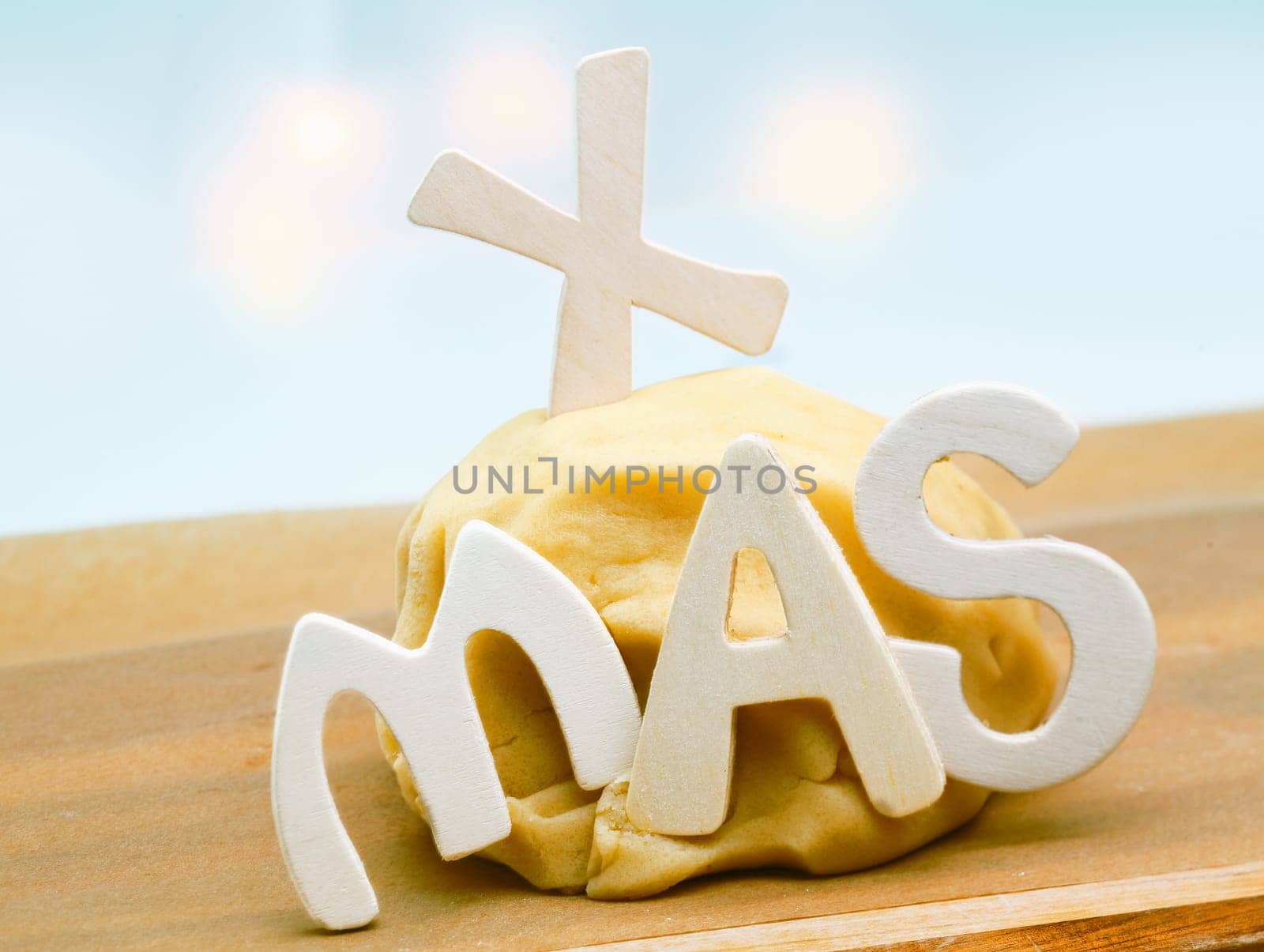 Seasonal background with freshly prepared dough left to rise on a kitchen countertop decorated with the letters XMAS for preparing Christmas cookies for family and friends