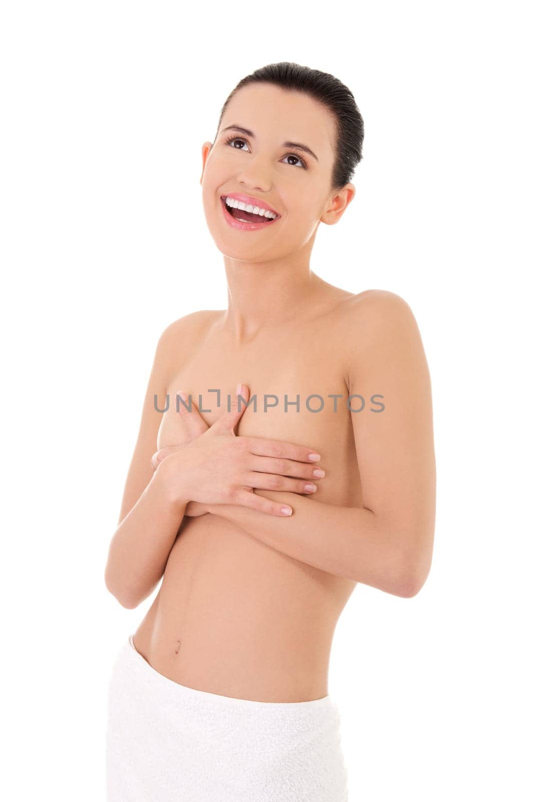 Happy young beautiful topless woman with perfect body wearing white towel around her waist.