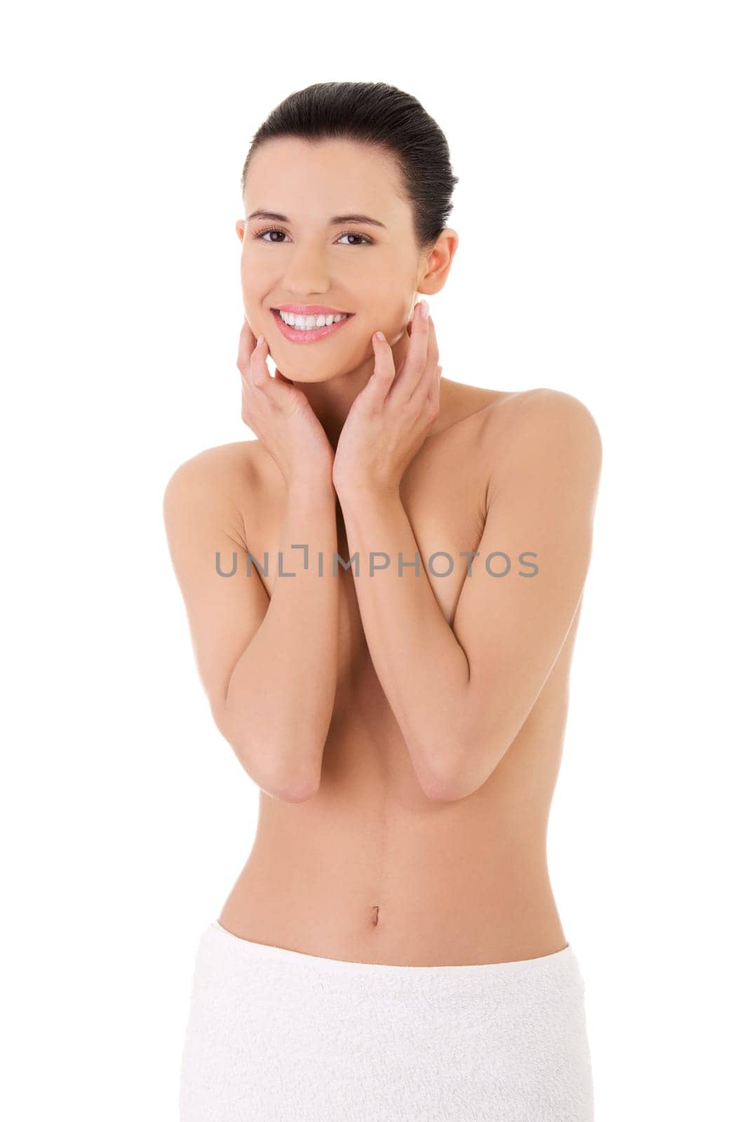Happy young beautiful topless woman with perfect body wearing white towel around her waist.