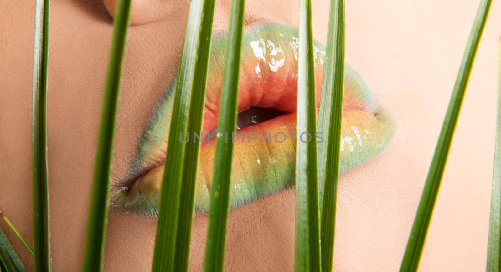 Woman's lips with green leafs