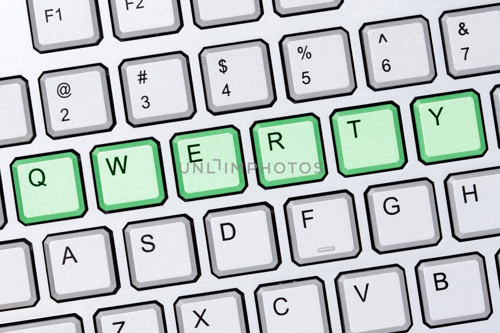 Green qwerty buttons on silver computer keyboard