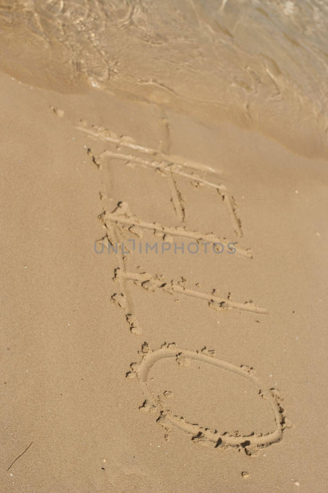 Hello word in the sand at the beach