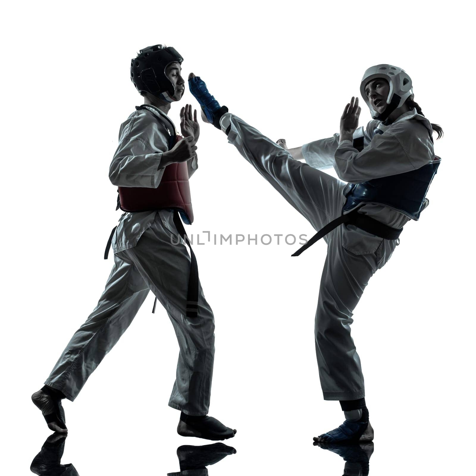 one couple man woman couple exercising karate taekwondo martial arts in silhouette studio isolated on white background