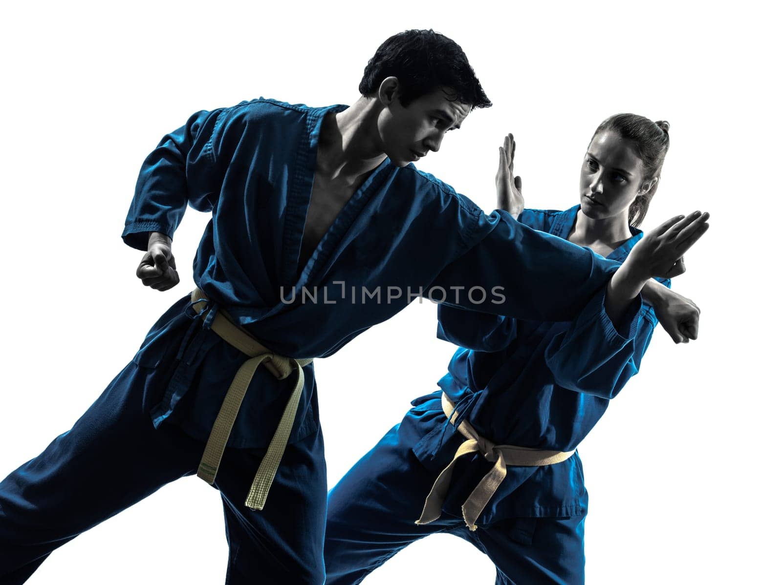 one  man woman couple exercising karate vietvodao martial arts in silhouette studio isolated on white background