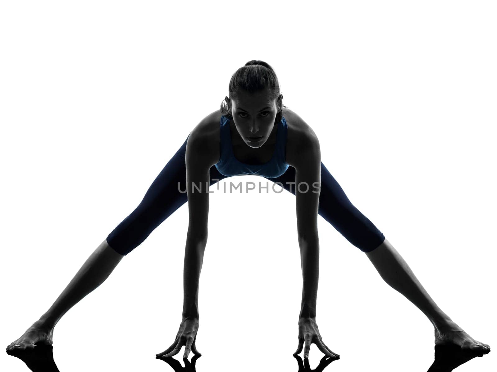 one caucasian woman exercising yoga stretching legs warm up in silhouette studio isolated on white background