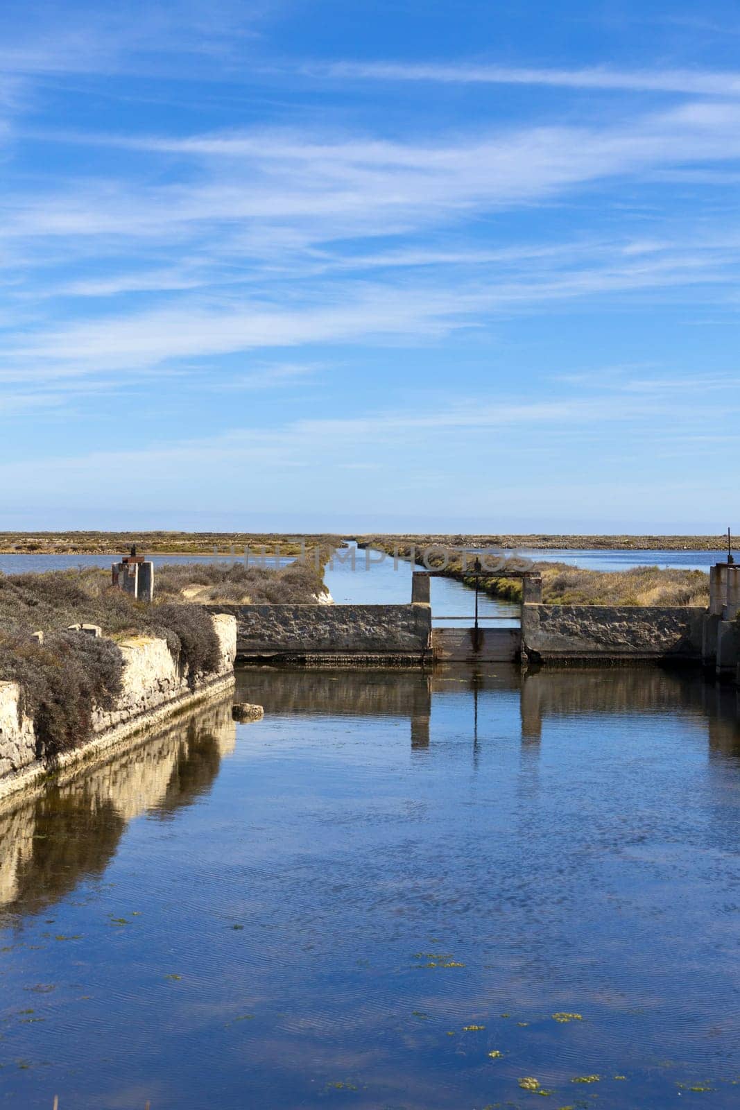 Old weir at the water channels of a salt works near Gruissan in southern France