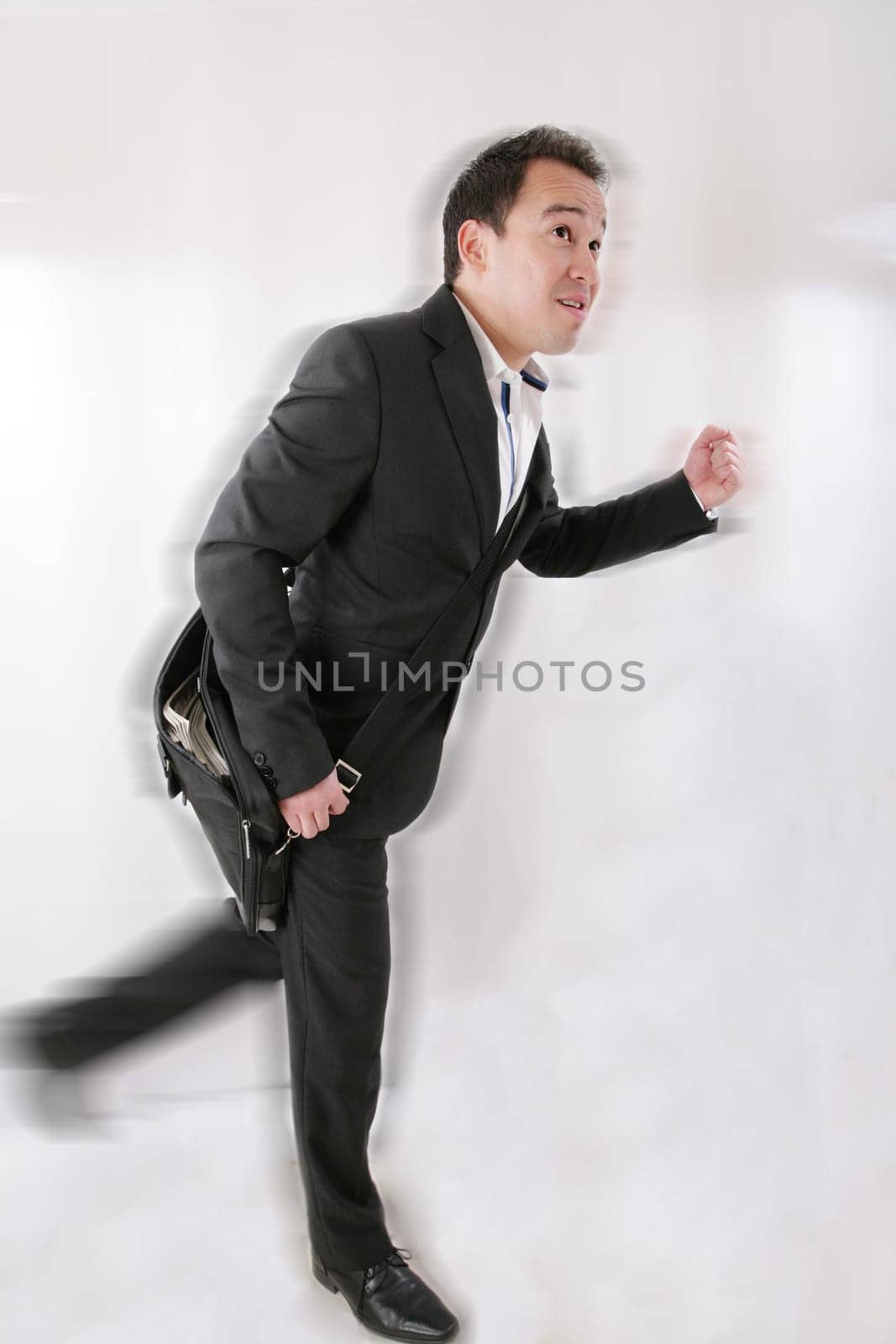 Full length of business man with briefcase running on white background