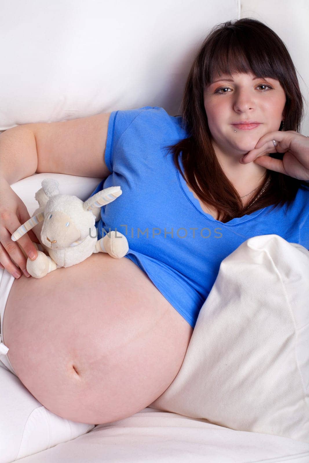 pregnant young woman with stuffed animal on belly