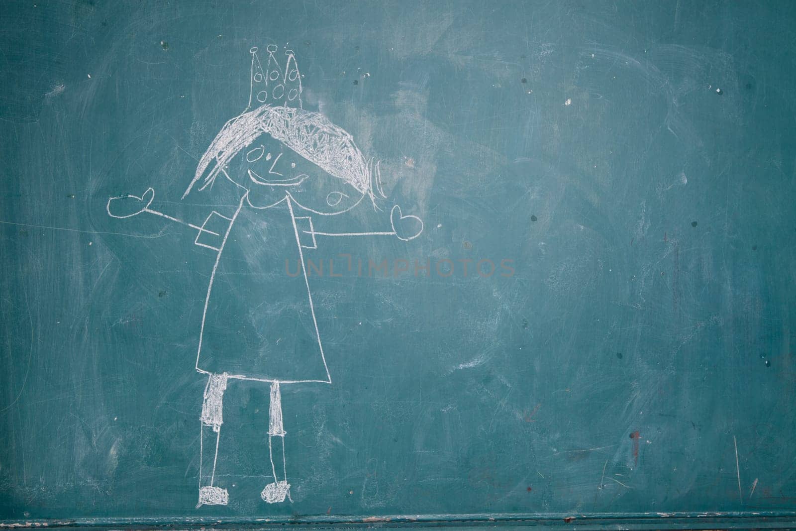 Image of smiling princess with crown drawn on chalkboard by young child