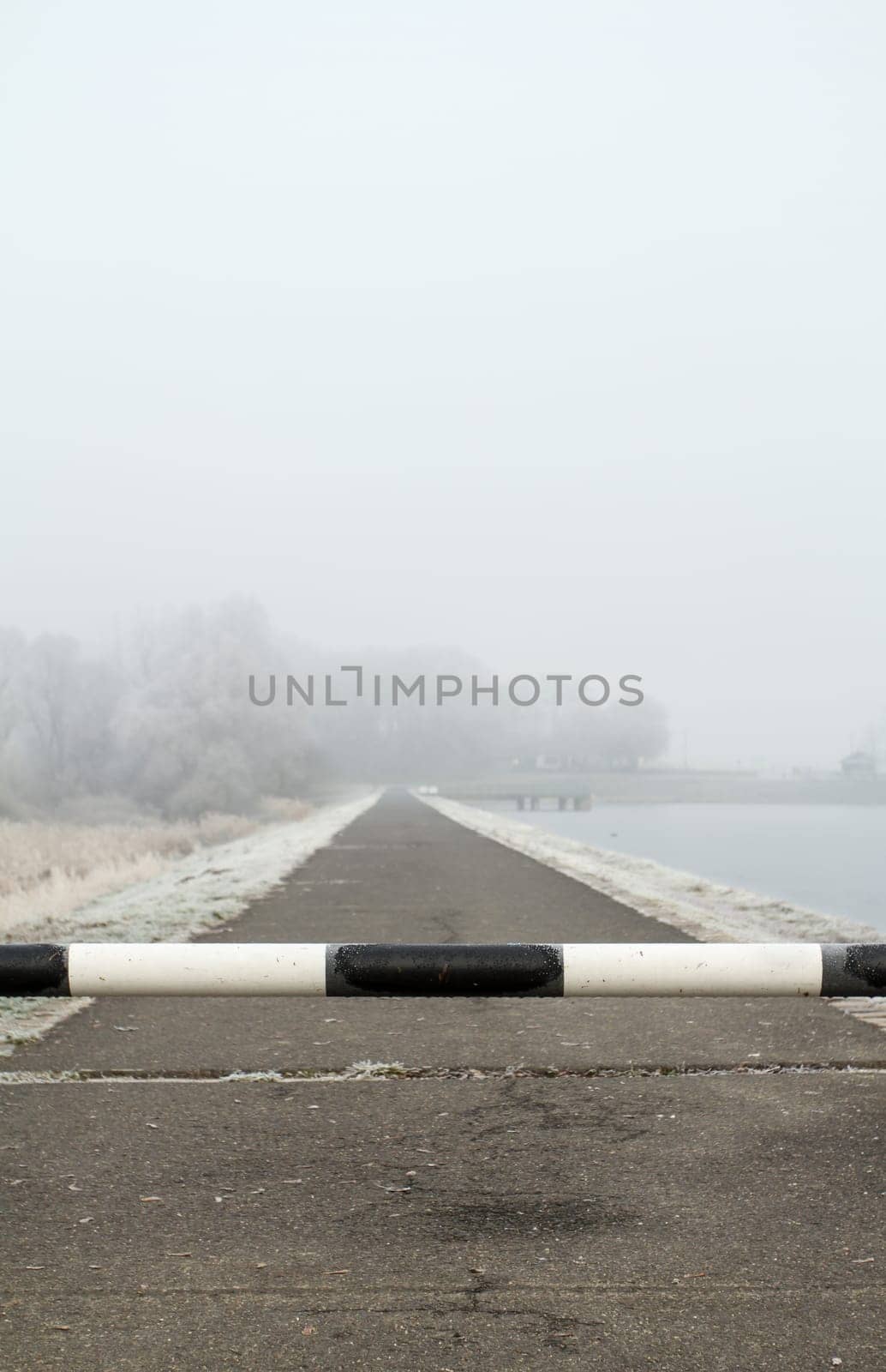 road to far away with barrier on freeze hoarfrosted landscape