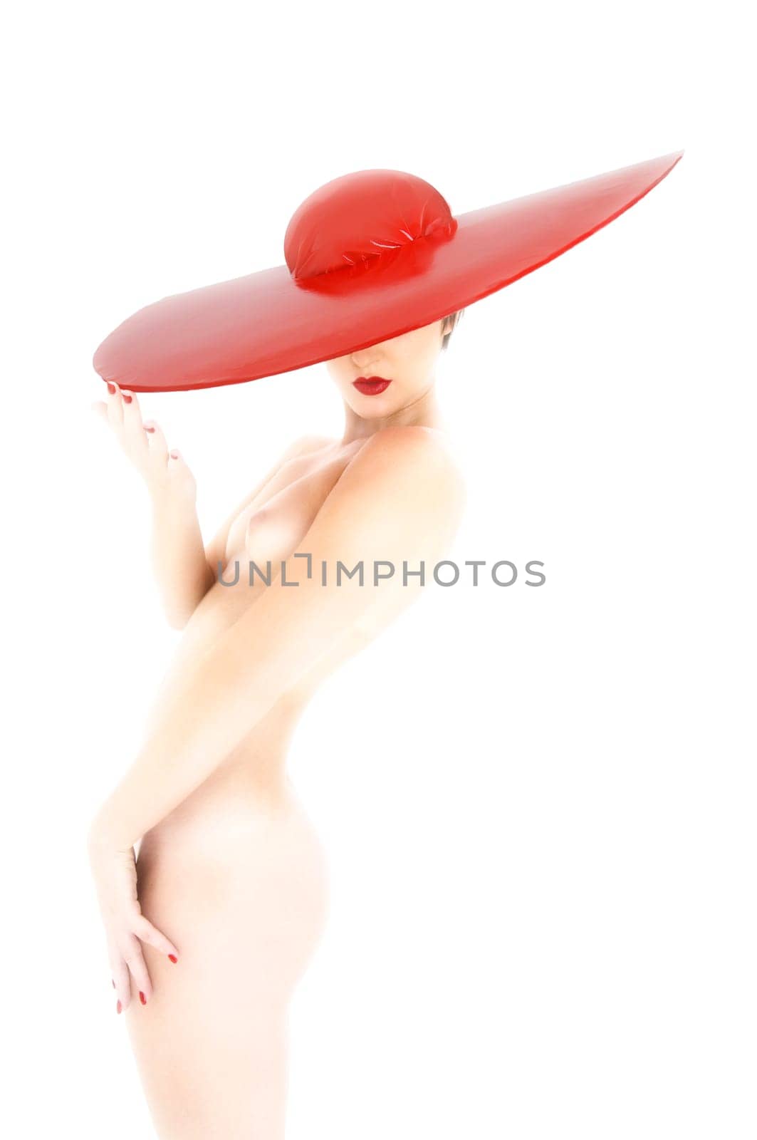 Female nude hi key with big red hat in side view