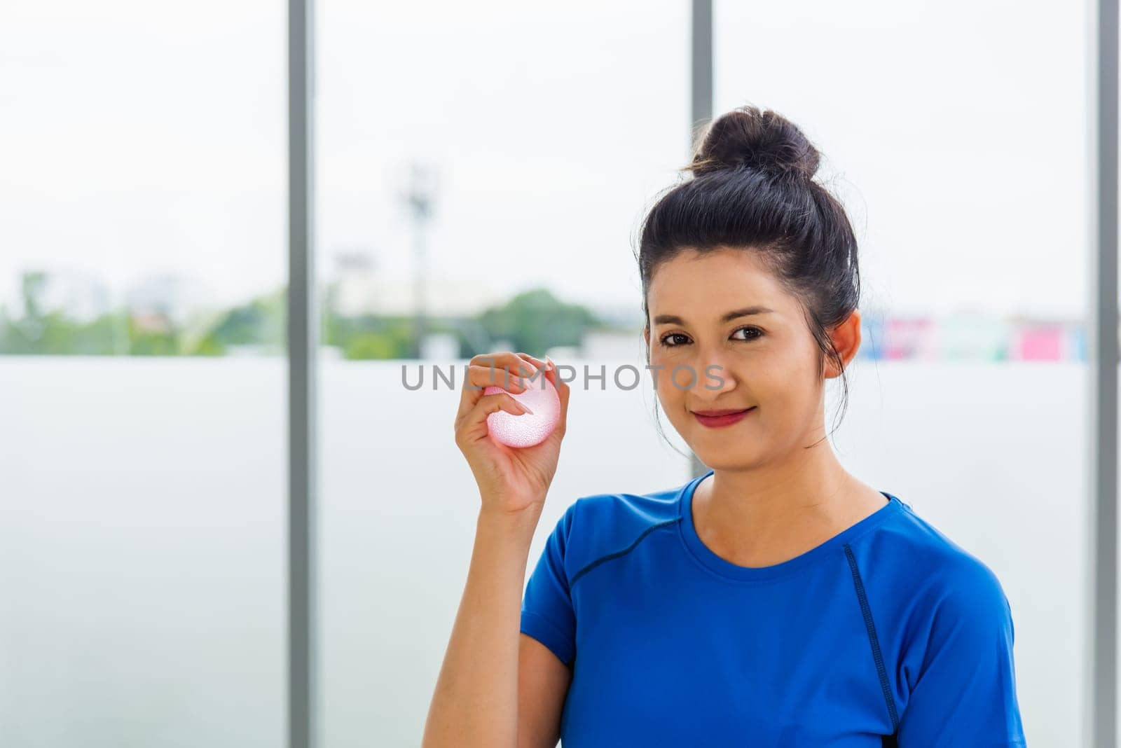 woman in sportswear holding the rubber ball hand grip exercise by Sorapop