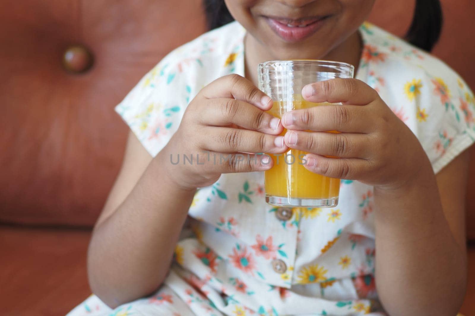 child hand holding a glass of orange juice by towfiq007