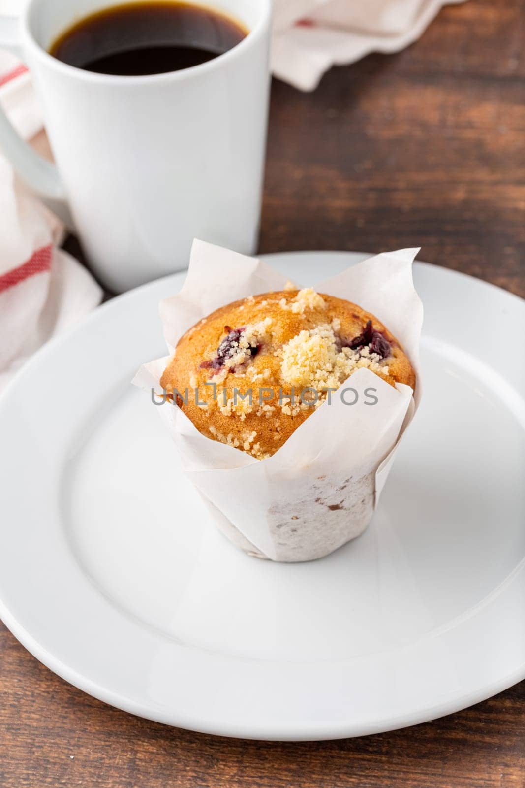 Vanilla and hazelnut muffin or cupcake with coffee on wooden table