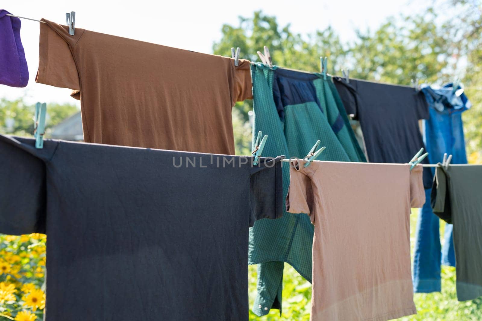 T-shirts drying on an open air on a sunny day by VitaliiPetrushenko