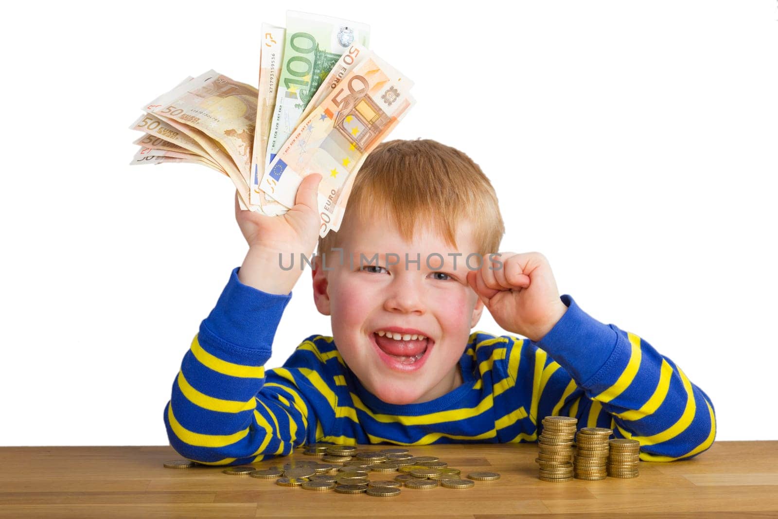 Cheering boy with banknotes in hand,sitting in front of coins