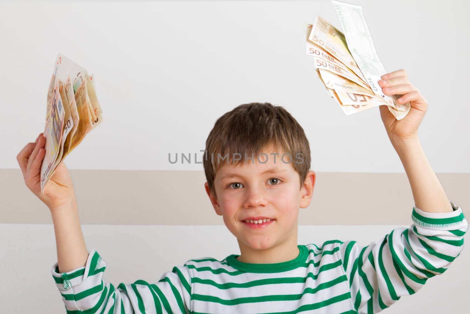 Cheering boy with banknotes in hand