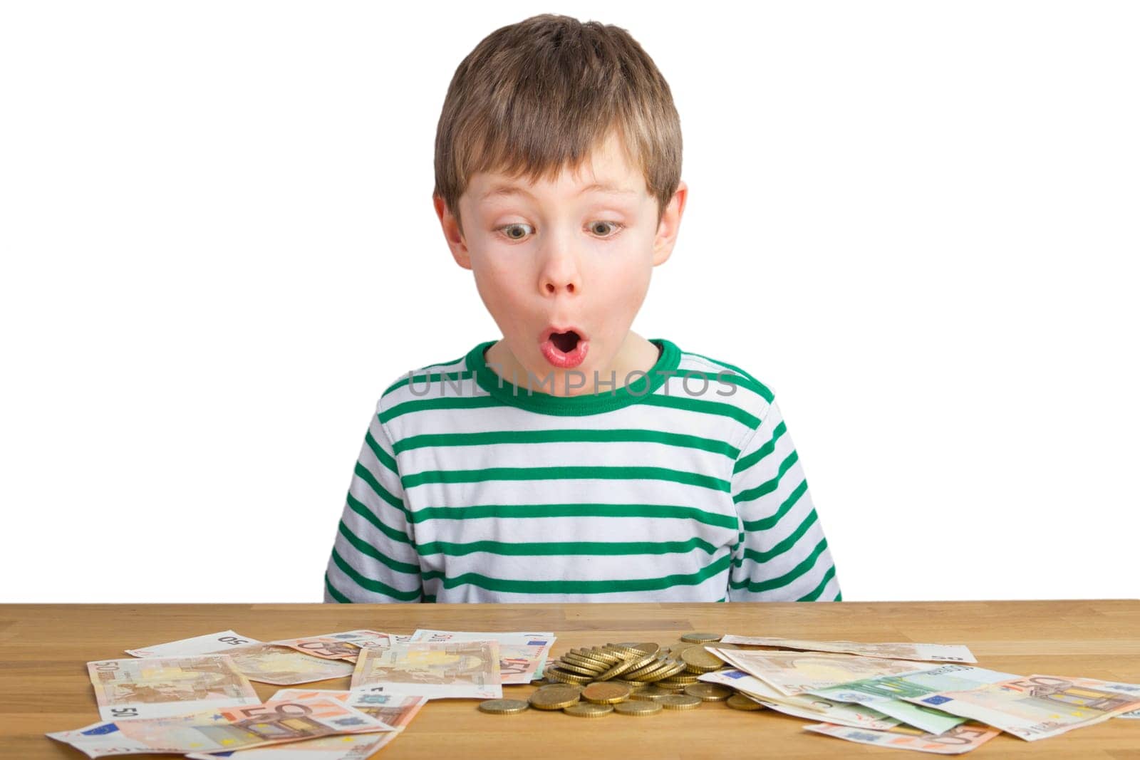 Boy sits in amazement in front of coins and bills