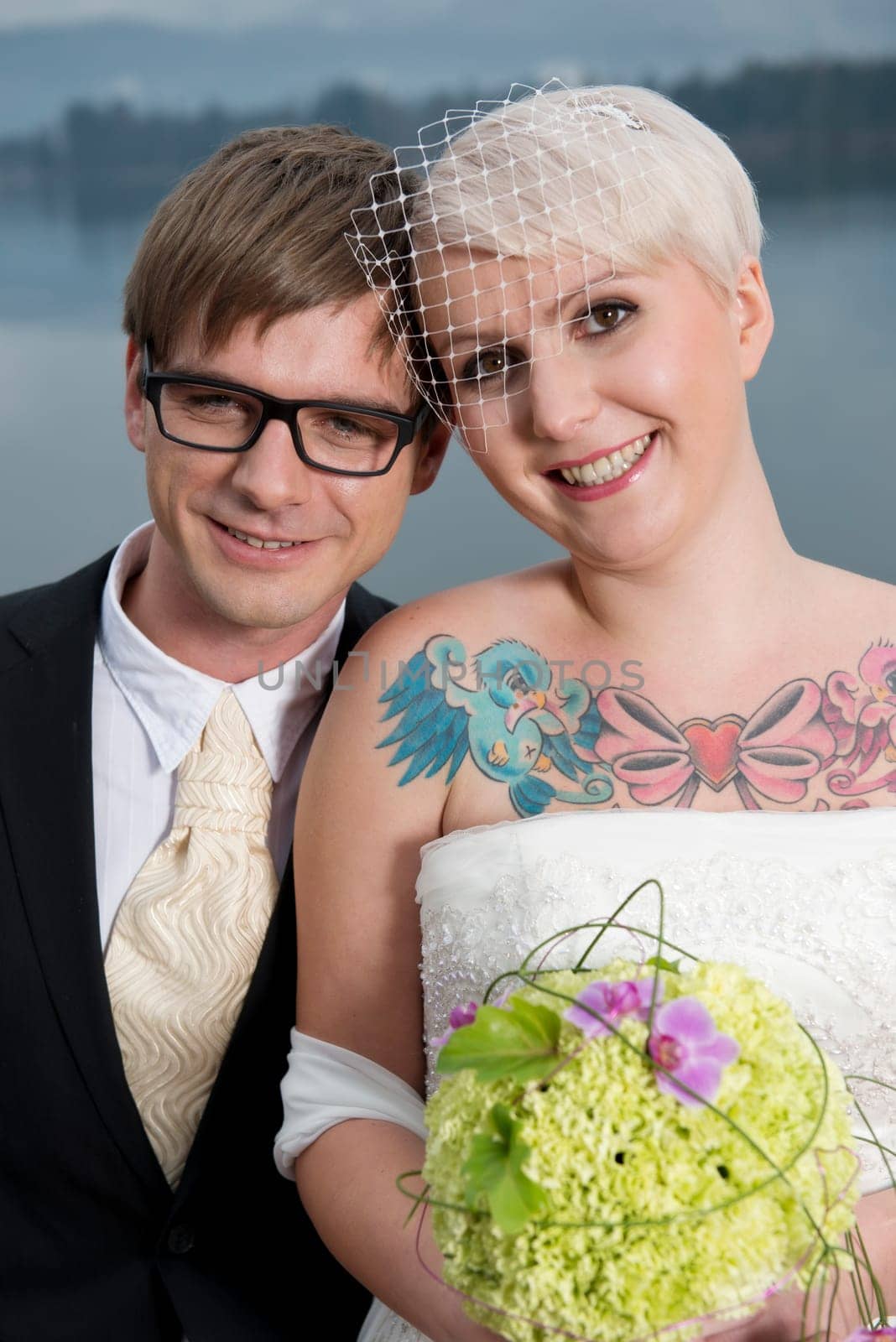 A young blonde bride with a tattoo and her groom