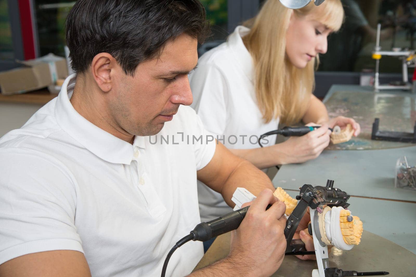 Dental technician working on a dental prosthesis in an articulator