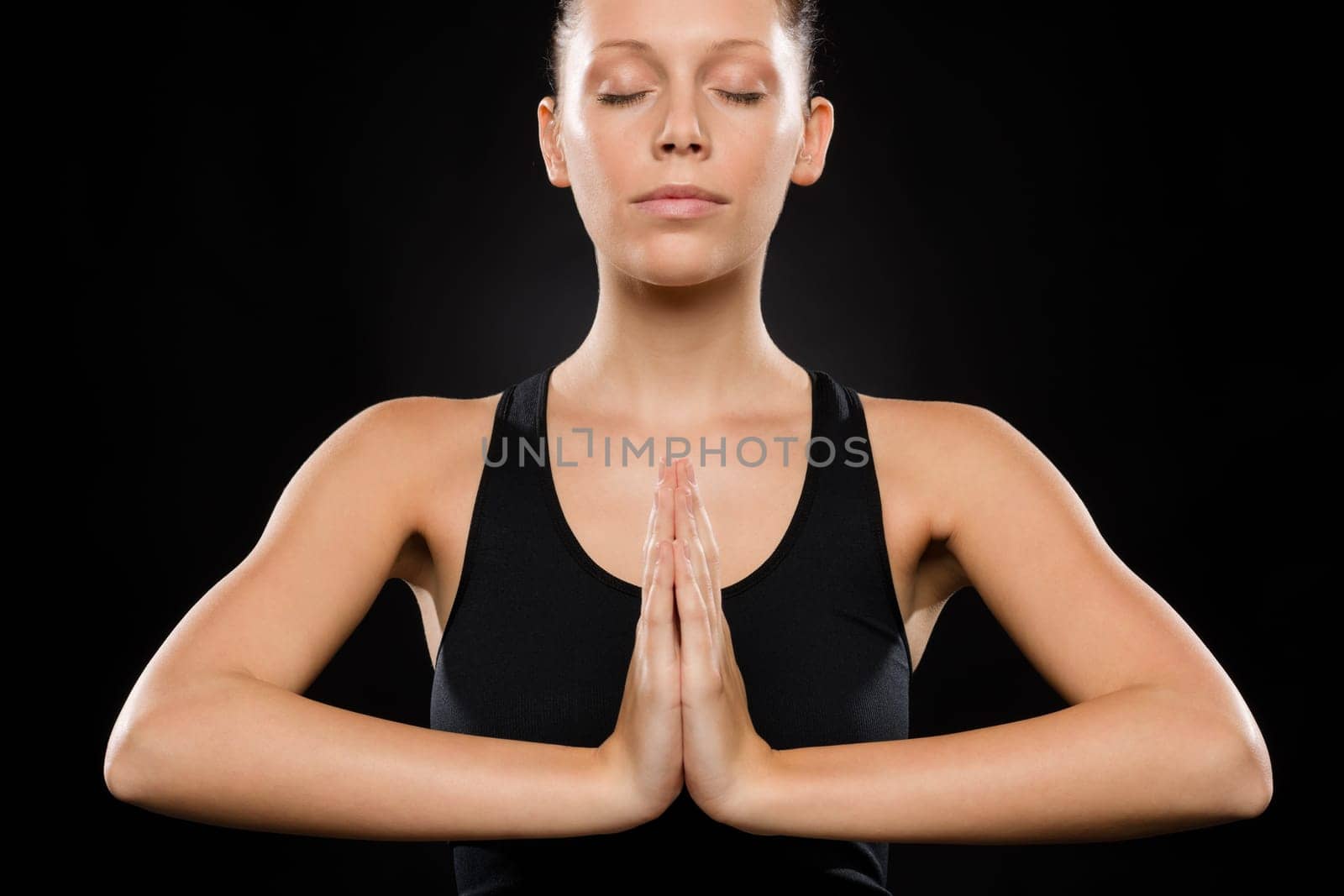 Portrait of young Caucasian woman exercising yoga with hands clasped